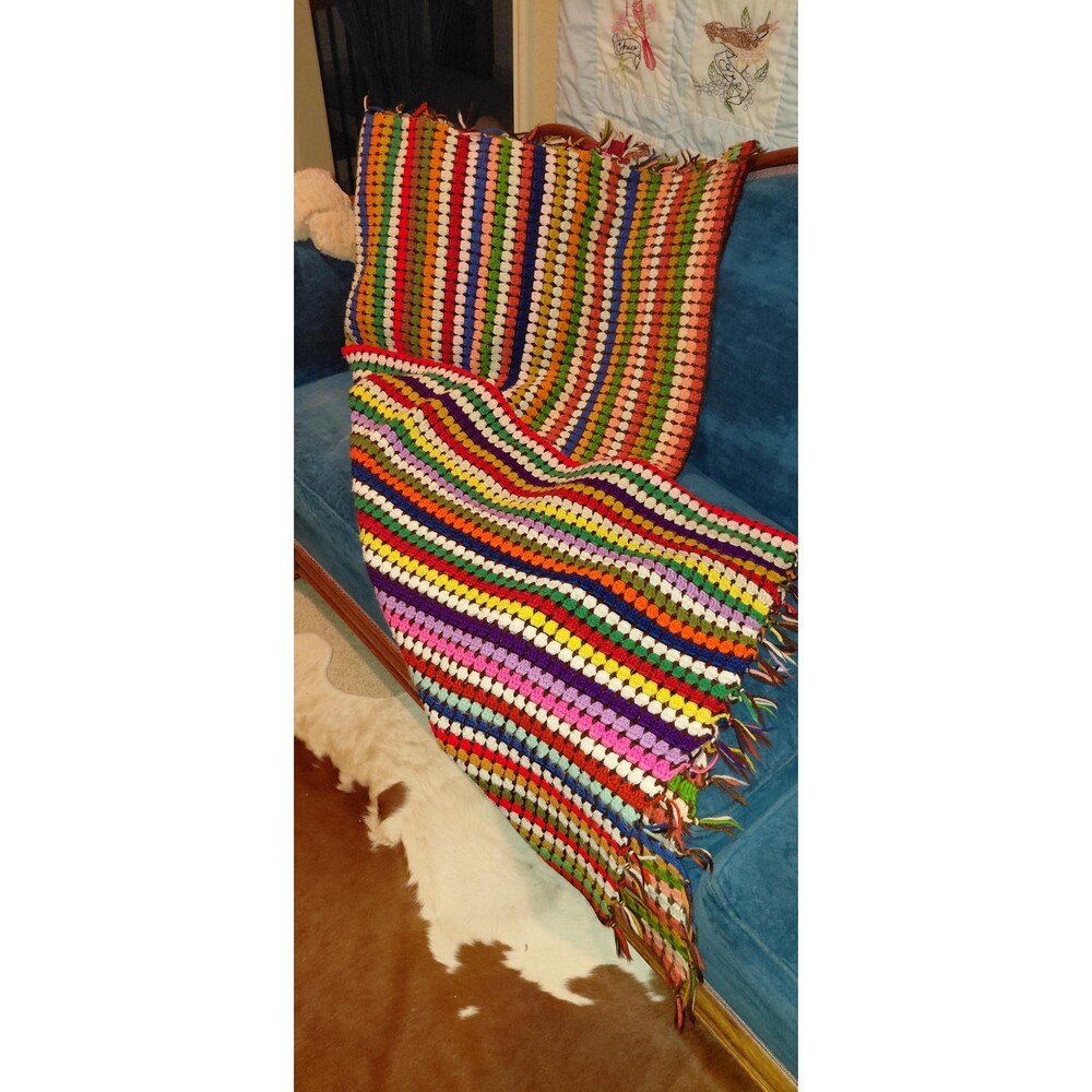 Handmade crocheted afghan throw blanket, featuring a colorful, striped stash-bus